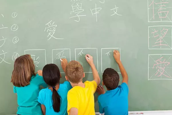 students writing on chalk board.
