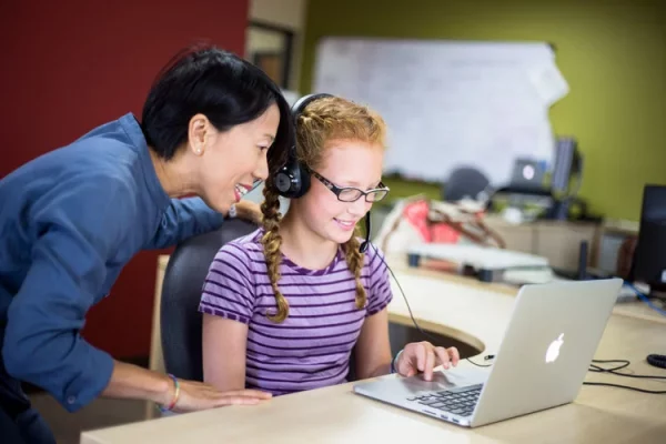 teacher helping student with assessment.