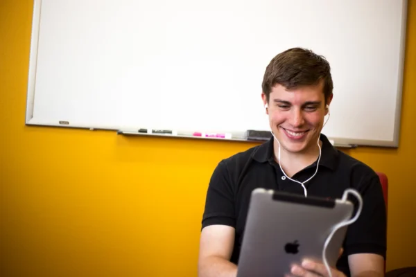smiling student with headphone taking assessment.